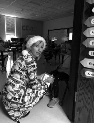 Kindergarten teacher Theresa Keller, dressed in her Santa Claus PJ’s on Pajama Day, has a conversation with a young student.