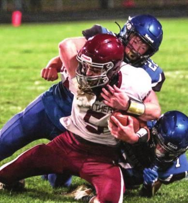 Lemmon/McIntosh’s Tell Mollman (22) and Riley Tennant (7) bring down Timber Lake’s Trenton Hansen during their game in Lemmon on Friday. Photo by Jon Flatland