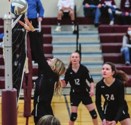 Harlee Hulm pushes the ball over the net as Jordan Jones (12) and Sara Holzer (24) watch during a JV match versus Bennett County.