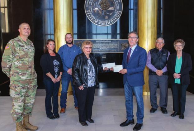 North Dakota Gov. Doug Burgum presents Ron Hepper’s military ID tag (dog tag) to his widow, Ruth Hepper of Bismarck and formerly of Isabel, on Wednesday, Sept. 30, at the North Dakota State Capitol in Bismarck. Also pictured are (L-R) Maj. General Al Dohrmann, Hepper’s daughter Julie Hornbacher and her husband, Jim, and Ron Hepper’s brother Stanley Hepper and his wife, Kathleen.