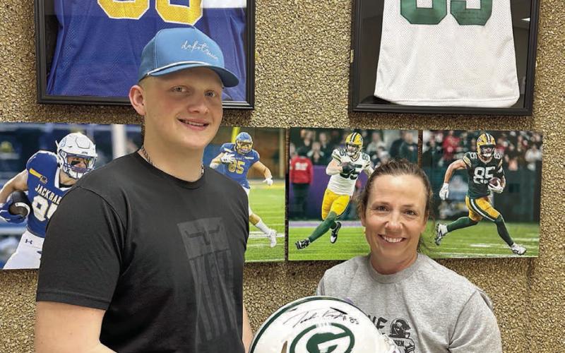 Mae Keller (RIGHT) took home the Green Bay Packers helmet autographed by Tucker Kraft with a bid of $20,000 at the benefit for Braylen Hansen (left), a senior at Timber Lake High School, held March 13. (More inside) Photo by Kathy Nelson