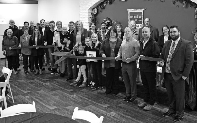 Theresa Stangle cut the ribbon on her new business, Reactive Wellness, at 109 West Main Street in Pipestone Tuesday, Nov. 15 during a Pipestone Area Chamber of Commerce ribbon cutting and ambassador visit. Pictured are Stangle (holding the big scissors), her husband Rich (left of her), their son Otto (being held by Rich), and their daughters (in front of Stangle, L-R) Gloria, Vera and Eleanor.