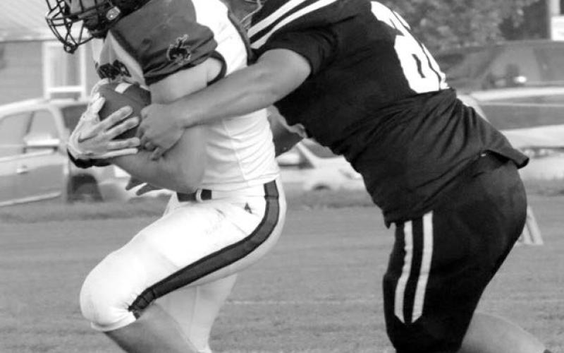 Senior lineman Dan Peterson wraps up a Lemmon-McIntosh runner during his return to the field last Friday after missing all of last season with an injury and immediately made his impact felt on both sides of the ball, protecting quarterback Gracen Hansen on offense and collecting four tackles and three assists, including two stops for lost yardage, on defense. Photo by Jon Flatland