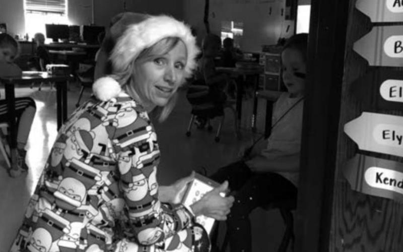 Kindergarten teacher Theresa Keller, dressed in her Santa Claus PJ’s on Pajama Day, has a conversation with a young student.