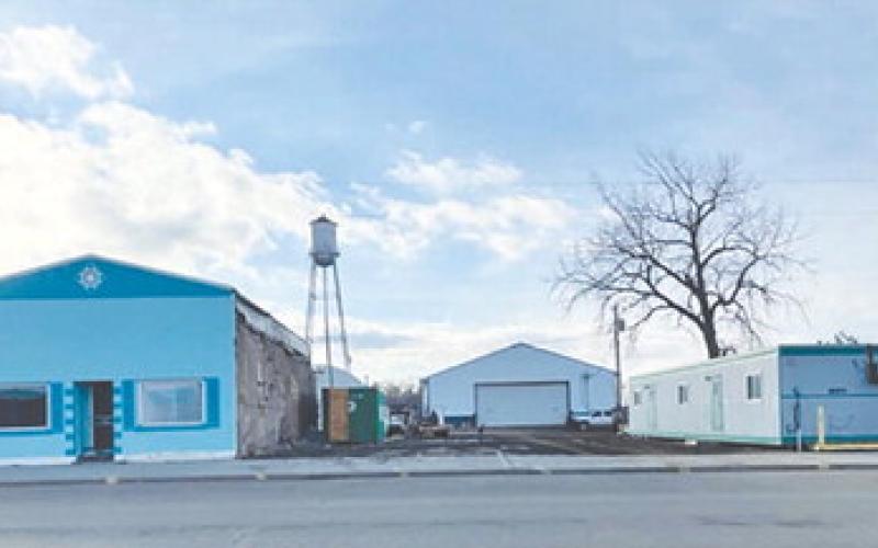 Demolition of the Schlosser building opened a spot where owner Stan Schlosser plans to move the small building shown at right to replace it. The blue building at left was formerly the Senior Center, then storage for Biegler Equipment, and later Lilian Turcotte’s vintage shop.