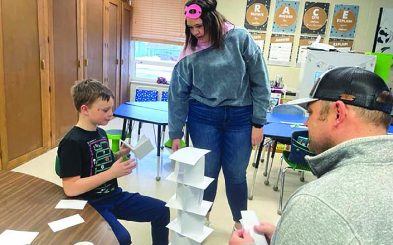 Keaton Jones builds a paper tower with only a little help from his teacher, Paige Bakken, and dad, Rio Jones.
