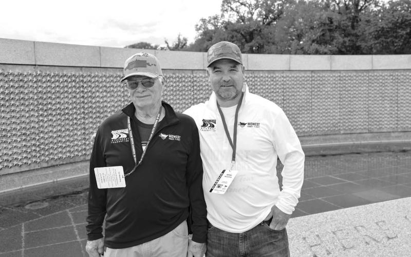Carl Winterberg (left) and his son Adrian (right) at the center of the World War II memorial, where each gold star represents 100 deaths that occurred during the conflict.