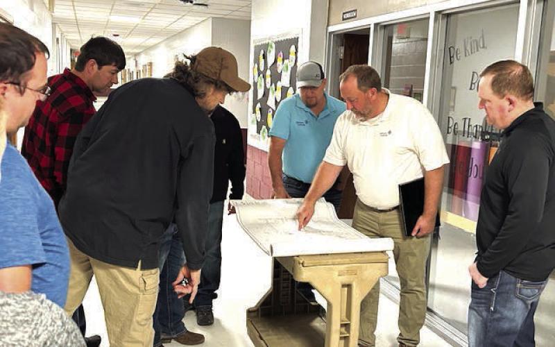 Representatives from Johnson Controls Inc. go over building blueprints with members of the Timber Lake School Board last Wednesday, March 13, during a tour of the school building and overview of heating and cooling improvements being made as part of a more than $1 million HVAC upgrade. Pictured l-r are TLHS Technology Coordinator Joel Schweitzer, board member Tyrone Kraft, board president Jake Kraft, Project Manager Terry Holland of Johnson Controls Inc,, project supervisor John Paul of Johnson Controls Inc