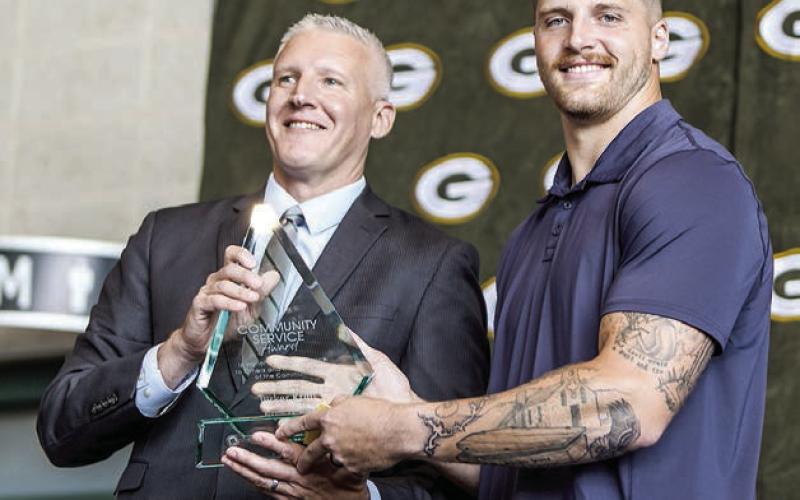 Green Bay Packers tight end Tucker Kraft, a native of Timber Lake, was presented the Packers 2025 Community Service Award last Friday, Aug. 22. Presenting the award was Ryan Krumrie, a partner at Hager, Dewick &amp;amp; Zuengler, S.C. and Chairman of the Greater Green Bay Chamber of Commerce. Photo by Madison Morris courtesy of Green Bay Packers.
