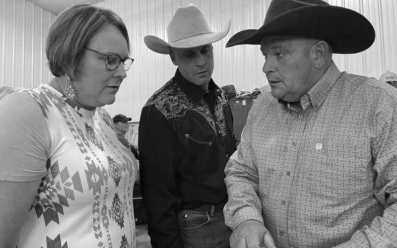 Laurie Bickel, Levi Goldade and John Hoven check the list of items for the live auction.