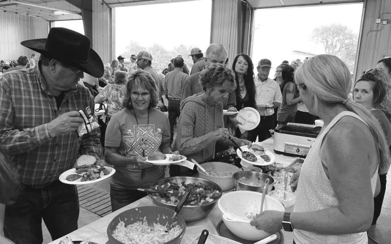 Arlyn and Cheryl Lawrence make their salad choices in the food line as Brenda Jones (RIGHT) helps serve.