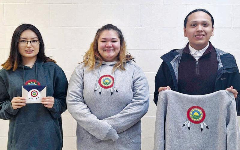 Dupree students who participated in the CRST Farm to School logo contest included (l-r): Jamie Black Moon (who won second place), Izzy Jeffries, and Wambli Quintana. They are displaying the winning logo, which was created by Alicia Condon, a student at Takini School. Photo by Patty Peacock