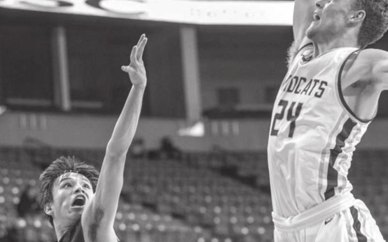 McLaughlin’s Evan Archambault tries to float a shot over the defense of Custer’s 6’5” center Gage Tennyson during the Lakota Nation Invitational. Photo by Robert Slocum