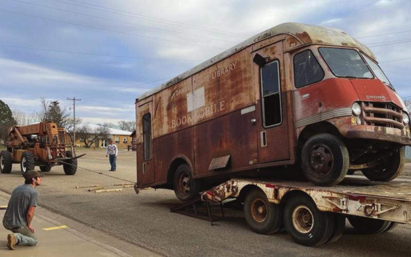 Michael Frank (FRONT) transported the bookmobile from Isabel to Timber Lake, where Marty and Scott Biegler and crew unloaded it. Troy Lindskov recently bought the vacant lot where it was sitting. He and his dad, Corey, helped load it onto Frank’s flatbed trailer. Photos by Kathy Nelson