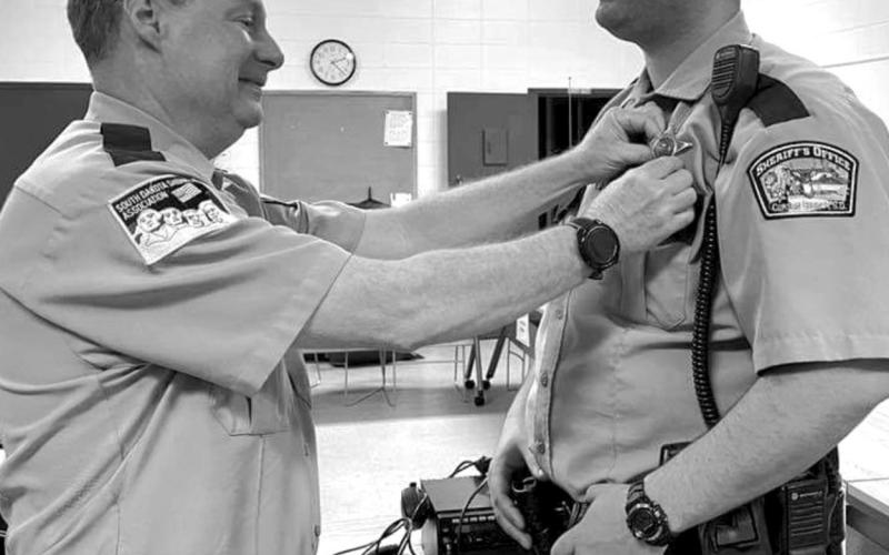 Retiring Corson County Sheriff Keith Gall (LEFT) pins the sheriff’s badge on his former deputy, Alan Dale, who was appointed sheriff effective March 13.