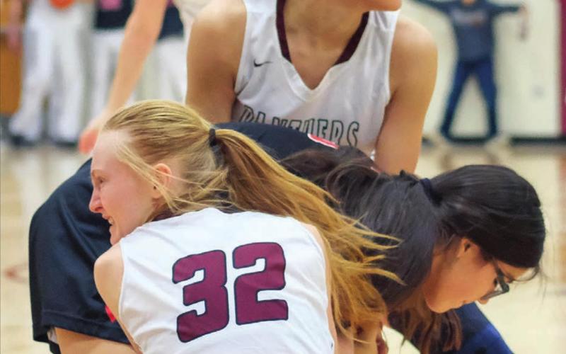 Timber Lake’s Jasmine Nash and Jordan Jones (32) tie up the ball with a Lyman player during their Dec. 28 varsity game in Timber Lake. Photos by Robert Slocum