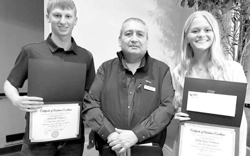 Each year the Cheyenne River Sioux Tribe Telephone Authority presents scholarships to the top two students in the graduating class of each local high school. At the May 6 TLHS awards program, Ken White Eyes of the CRSTTA (middle) presented the salutatorian scholarship to Holden Gill (left) and the valedictorian scholarship to Hailey Roggow (right).
