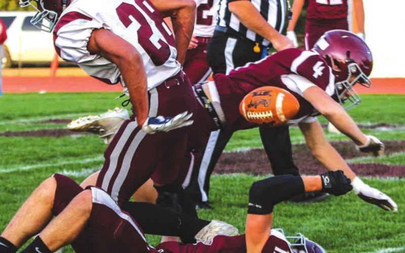 LEFT: Timber Lake defenders Gracen Hansen (4) and Jayce Lawrence (19) knock the ball loose from the grasp of Newell’s Nate Randolph (28) during their game last week. Photos by Jon Flatland