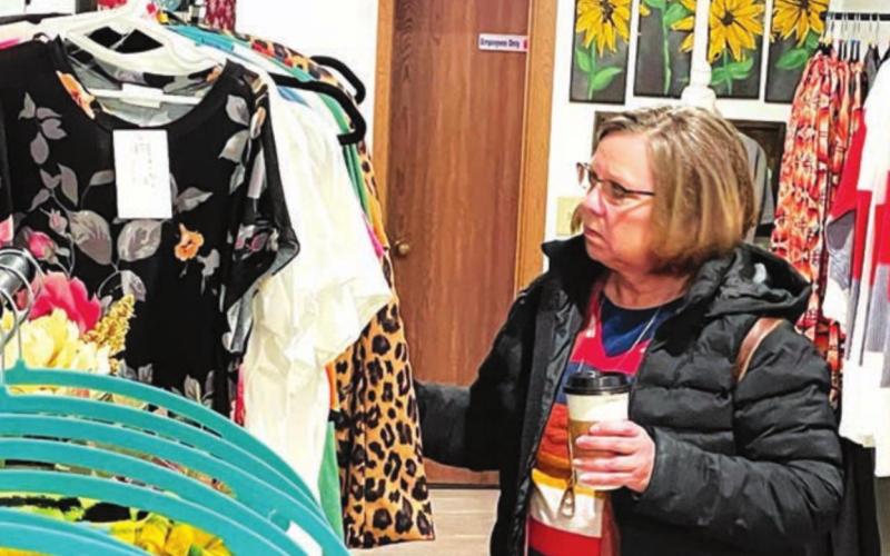 Local shoppers at the Timber Lake Christmas Extravaganza on Dec. 3 included (ABOVE LEFT) Don Schott at Country Market, and (ABOVE RIGHT) Leann Lindskov at Boutique #246. BELOW: Sarah Schweitzer (LEFT) assists Joann Beyer at Dakota Silk Screen. Photos by Kathy Nelson