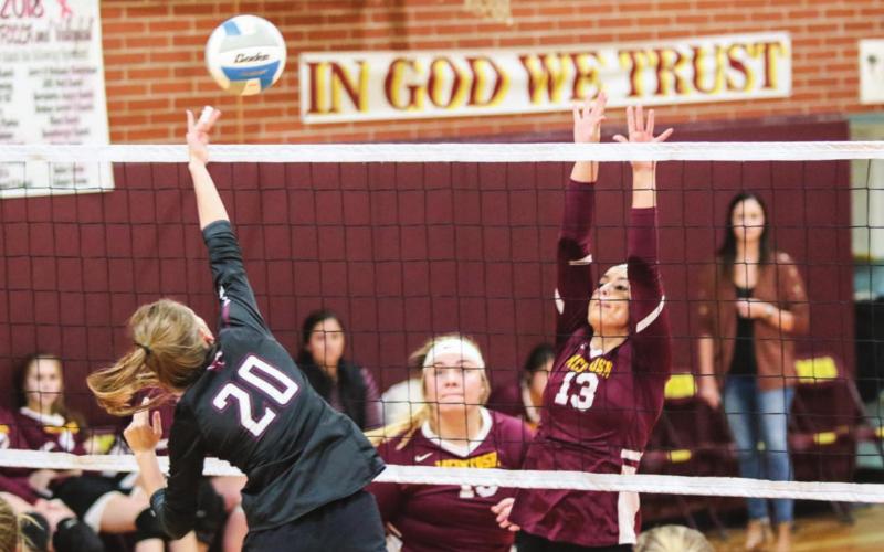 Timber Lake middle hitter Molly Kraft (20) powers a spike past the defense of Mcintosh's Meghan Maher (13) and Reyna Nehl (15) during varsity volleyball action on Oct. 1 in Mcintosh. Photos by Jon Flatland