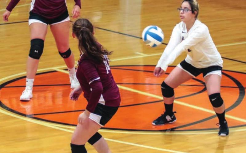Mcintosh's Abby Iron Wing bumps a serve from Timber Lake as teammates Chloe Sandland (11) and Irian Mittleider look on.
