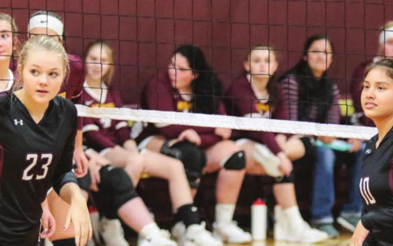 Stormi Hulm (23) and Cassie Carter (10) await a serve from a teammate during volleyball play in Mcintosh recently.