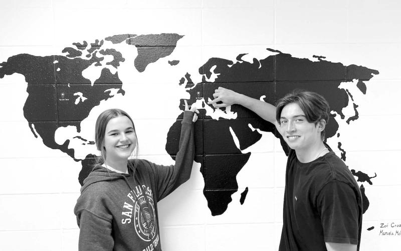 Exchange students Carla del Rio Larrea (LEFT) and Francesco Barbini point to their homes in Spain and Italy. The map was painted in the hallway at Timber Lake High School by last year’s exchange students.
