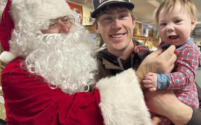 J.D. Enright introduces his baby boy, Denver Richard, to the “jolly old elf ” at the Timber Lake Museum on Monday. Santa and Mrs. Claus visited with about 70 children. Their visit and other Community Christmas activities were sponsored by Timber Lake Area Development and Western Dakota Bank. Topic Photo/Kathy Nelson