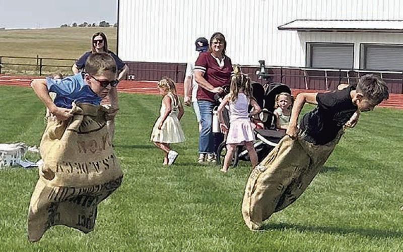Lincoln Aberle (left) and Gunner O’Leary (right) racing to the finish in the potato sack race. Photo By Ann Arnold