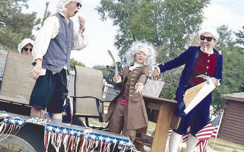 Garrett Nilson (left), Broay Biegler (middle), and Kaleigh Biegler (right) having a blast on the Timber Lake Museum float. Photo By Ann Arnold