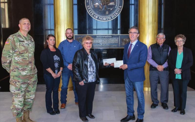 North Dakota Gov. Doug Burgum presents Ron Hepper’s military ID tag (dog tag) to his widow, Ruth Hepper of Bismarck and formerly of Isabel, on Wednesday, Sept. 30, at the North Dakota State Capitol in Bismarck. Also pictured are (L-R) Maj. General Al Dohrmann, Hepper’s daughter Julie Hornbacher and her husband, Jim, and Ron Hepper’s brother Stanley Hepper and his wife, Kathleen.