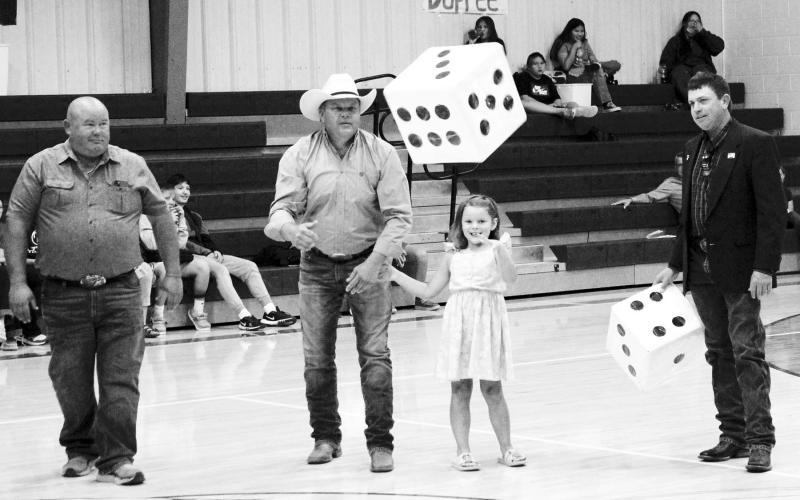 During the DHS coronation, staying with the “Tigers Win Games” theme, a cute skit using board games in their answers to how the Tigers will win was performed by students. A round of bingo was played, and for a dice game of 6-5-4 parents of seniors were invited to play. In the photo, Jayde Starr, with his daughter Hadley who came along to help, are giving the dice a big toss as (L) Shane Farlee and (R) Kerry McLellan wait their turn to roll the dice. In the end, Mika Tibbs won the bingo game and gifted her w