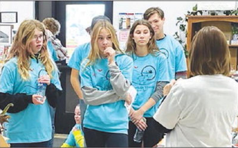 Teacher Jae White gives the blue shirt team instructions on the scavenger hunt at the Timber Lake Museum.