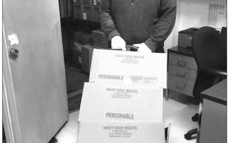 Jayme Murray wheels the first 450 pounds of donated beef into the school kitchen freezer.