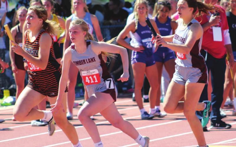 ABOVE: Shay Kraft hands the baton to Averie Marshall in the girls 400 meter relay state finals, in which the team, including Maci Maher and Kiya Mowrer, broke the school record. Photo courtesy of SD Public Broadcasting