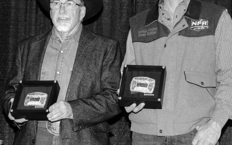 Dallas Schott (left) of McLaughlin and Brent Sutton of Sutton Rodeos, accept the buckles for the Bull of the Year and Bull of the Finals following this year’s PRCA Badlands Circuit Finals last month. Schott in the Dark - a son of the famed bull Bushwhacker - was crowned Bull of the Year.