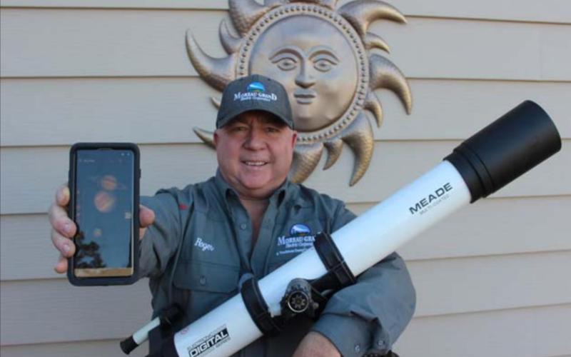 Amateur astronomer Roger Lawien shows off his telescope and the cellular telephone app he uses to help him find planets, stars and constellations. Photo by Jon Flatland