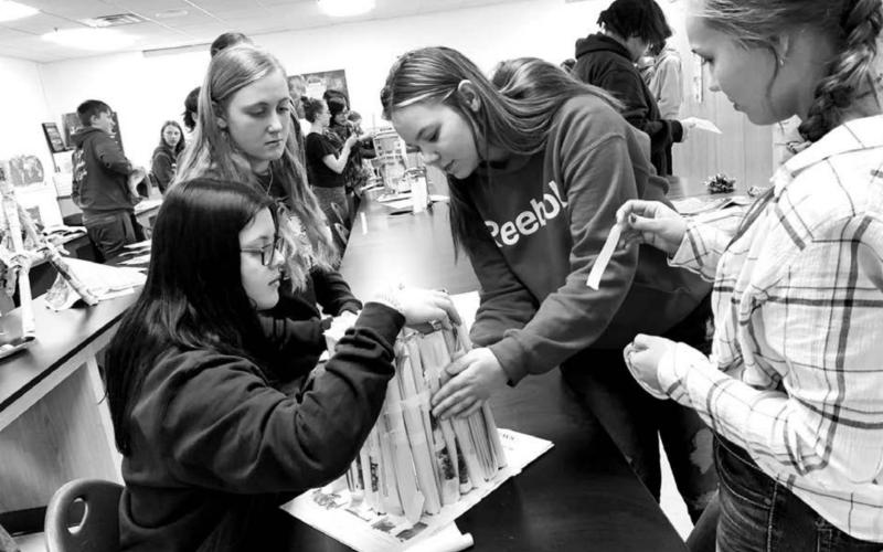 Seniors Michaela Hoyt and Cassie Harris (RIGHT) were the student-teachers who showed eighth graders Presley Goldade and Emma Johnston how to build a tower from newspapers.