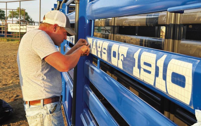 Mark Leibel, pictured, and other members of the Timber Lake Rodeo Association board of directors placed decals and sponsor panels on the seven new bucking chutes at the rodeo grounds in preparation for the Days of 1910 Rodeo this weekend. The SDRA/NRCA rodeo performances are set Saturday and Sunday nights at 6 p.m. and Sunday slack is at 8 a.m. Photo by Kathy Nelson