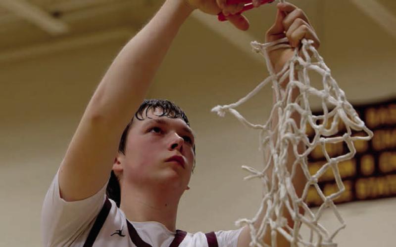 Rance Martin, the only senior on Timber Lake’s boys basketball team this season, cuts down the net after the Panthers beat Faith last Friday to advance to the SoDak 16. Topic Photo/Marie DuPreez