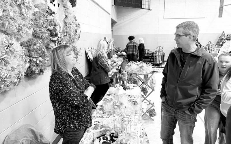 The annual Timber Lake Fall Craft Fair is part business and part social event. TOP: The Mettler sisters brought tshirts from Kristie’s Wokini Apparel Boutique to the craft fair. Kristie Lanke (LEFT) lives in Braudus, MT and sister Meagan Mettler teaches math in Spearfish. RIGHT; Monica Mayer of Isabel and Bryce Schaffer of Timber Lake hadn’t seen each other in a while. Photos by Kathy Nelson