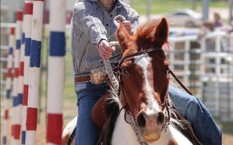 McKenzie Longbrake of Dupree weaves trhough the poles on her horse. Photo by Jon Flatland