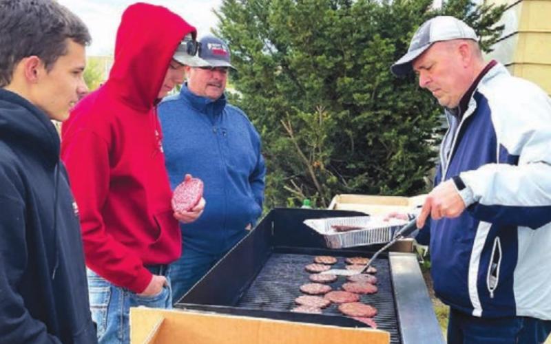 LEFT: Supt. Dan Martin (RIGHT) manned the grill, as Jayme Murray, director of the CRST Buffalo Authority (BACK, LEFT) and students James Bowlby and Ethan Goldade offered advice.
