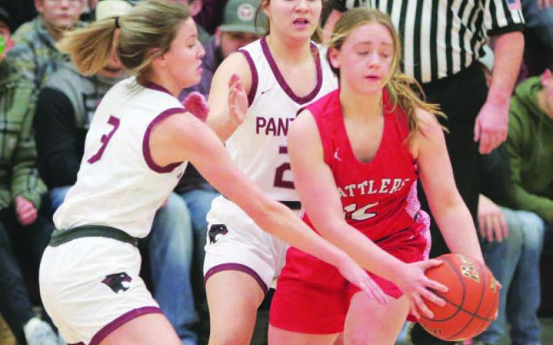 Lady Panther defenders Carlie Lawrence (3) and Abby Linderman utilize a half-court trap press to tie up Potter County’s Ashlee Kaup and ultimately force a turnover during first half action of Timber Lake’s win over the Battlers last week. Photo by Jon Flatland