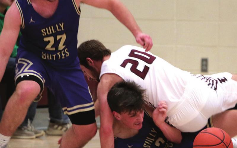 Timber Lake senior Brandt Ducheneaux (20) falls on Landon Hepker of Sully Buttes as they and the Chargers’ Jordan Schall (22) try and gather a loose basketball during their game this week. The physical play between the two successful programs has become customary in their non-conference regular season meetings.