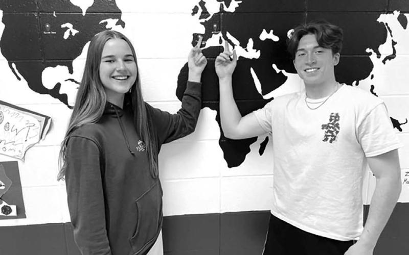 Photo by Kathy Nelson Exchange students Carla Del Rio Larrea (LEFT) and Francesco Barbini point to their home countries of Spain (Carla) and Italy (Francesco) on the map at Timber Lake High School. Carla spent the school year with Bryce and Colette Schaffer, and Francesco was hosted by Leah Peterson and her son Dan. The map was created by last year’s exchange students.
