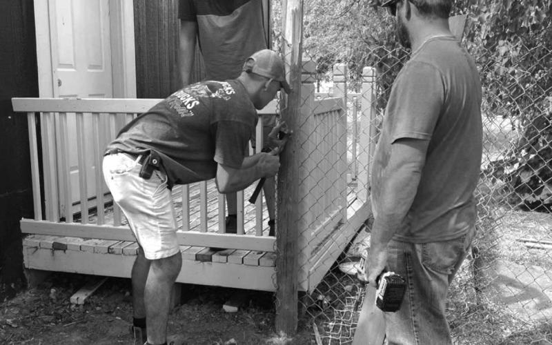 Volunteers work on fencing in the yard of a residence in McIntosh that is housing the new community daycare operation. The daycare opened Monday, Sept. 20, with its first seven children enrolled. Submitted photo