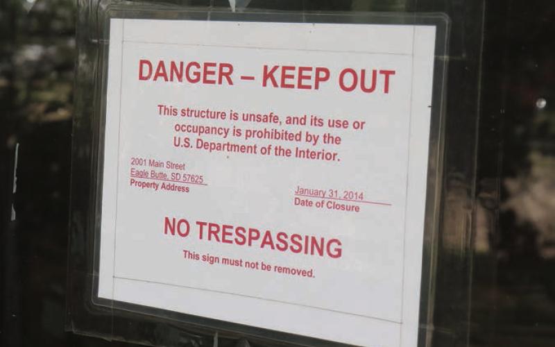 A sign on the front door of the former CRST Tribal Headquarters building in Eagle Butte shows Jan. 31, 2014, as the date it was closed and abandoned due to mold and other issues. Photo by Jon Flatland
