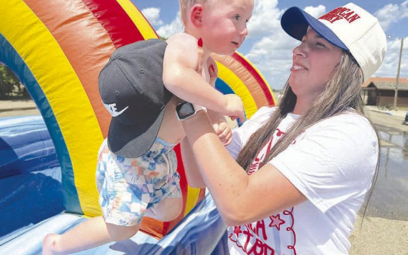 Josie White helps son, Cash, test the water at the Timber Lake Fire Department’s Family Fun event.