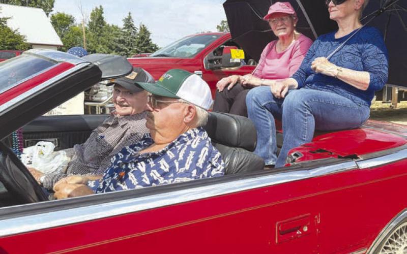 Parade marshals, driven by Marty Biegler in his red convertible, were (front) Rod Enright, his wife Mavis Enright (in blue) and her sister, Frances Marshall (in pink).